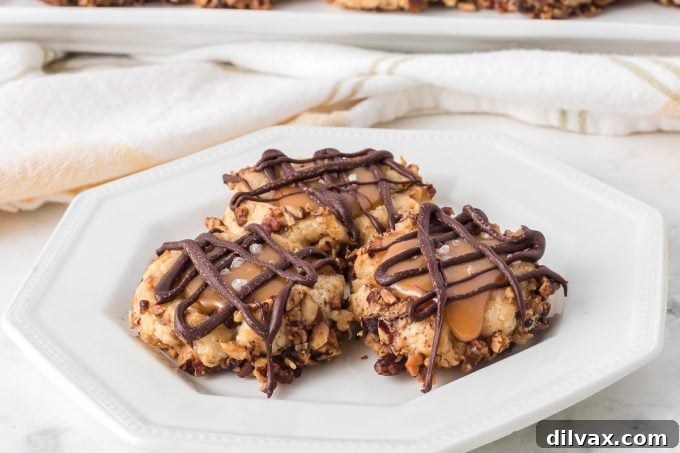 Golden Caramel Thumbprint Bites 2 Exquisite Caramel Thumbprint Cookies arranged beautifully on a serving tray, highlighting their golden shortbread, crunchy pecan coating, and glossy caramel and chocolate toppings.