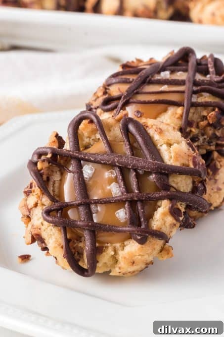 Golden Caramel Thumbprint Bites 11 A plate full of golden brown Caramel Thumbprint Cookies, each with a neat caramel filling and chocolate drizzle.