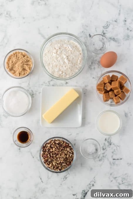 Golden Caramel Thumbprint Bites 4 A collection of fresh ingredients laid out on a kitchen counter, ready for making Caramel Thumbprint Cookies, including flour, butter, sugars, pecans, chocolate chips, and caramel candies.