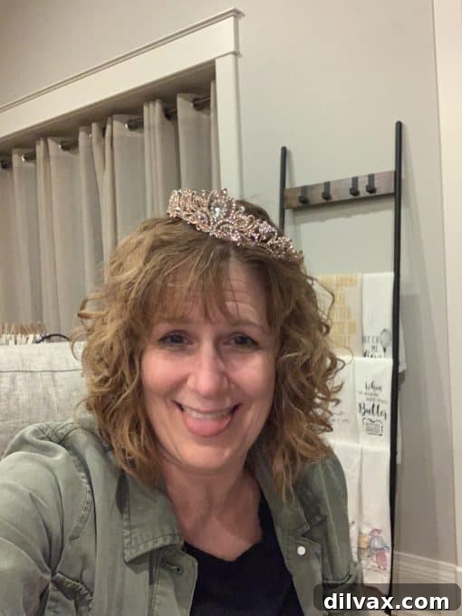 The December 9th Digest 2 Blogger wearing a tiara and making a silly face with a big smile, enjoying a fun moment during a trip with friends.