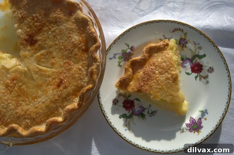 A close-up of a slice of pineapple pie revealing the generous crushed pineapple filling and golden crust.