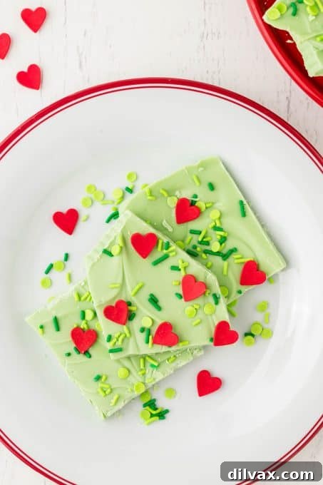 White chocolate bark with green sprinkles and red hearts for a Grinch theme.