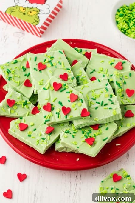 A plate full of white chocolate bark that is Grinch themed.