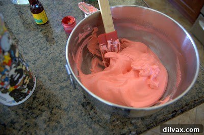 Mixing red food coloring into meringue