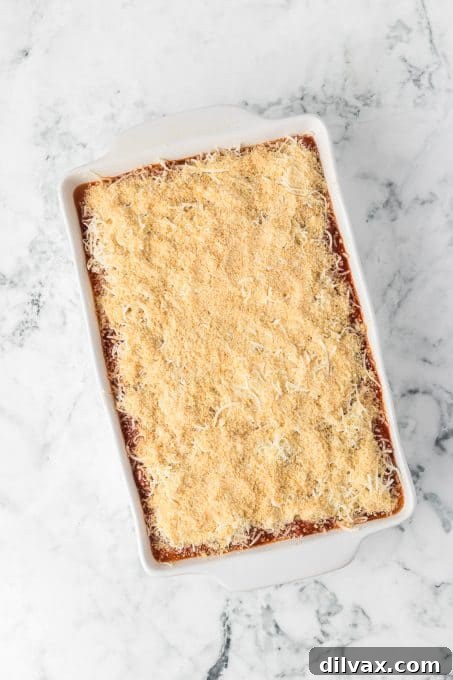A large baking dish of Ravioli Lasagna, freshly out of the oven, with golden-brown cheese.