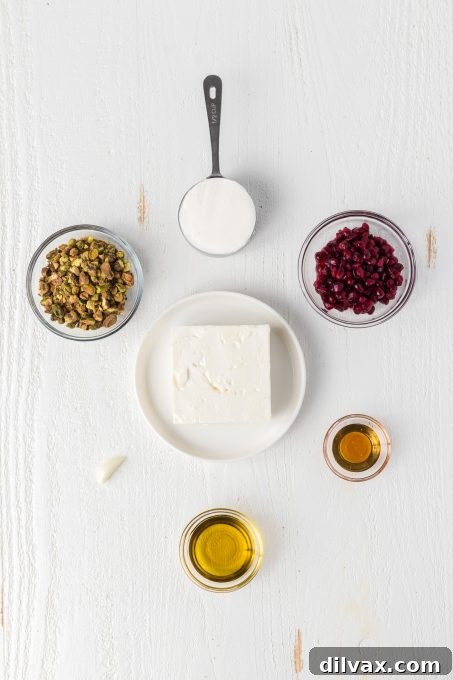 Key ingredients for the whipped feta cheese recipe including a block of feta, Greek yogurt, olive oil, and garlic.