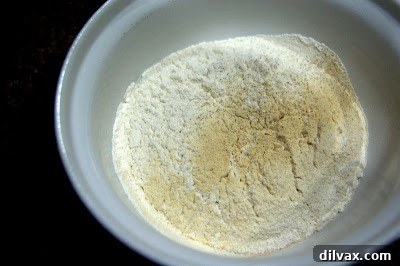 Sifted dry ingredients including flour, spices, and baking soda in a bowl, ready for mixing