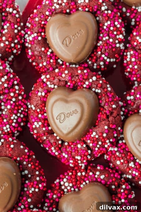 Valentine nonpareils cover a red velvet cookie that has a chocolate heart in the center.
