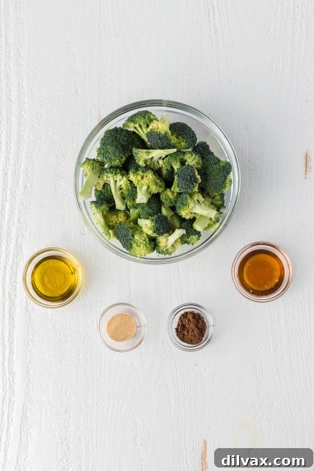 Garam Masala Roasted Broccoli 4 A collection of fresh ingredients laid out for making Garam Masala Broccoli, including broccoli florets, olive oil, honey, and spices.