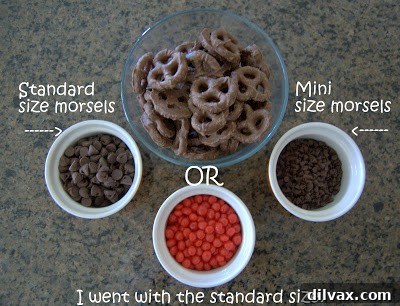 Close-up of a decorated Peanut Butter Reindeer Cookie with chocolate antlers, chip eyes, and red hot nose.