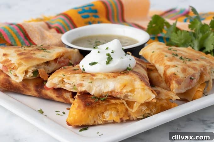Golden brown chicken quesadilla halves stacked on a cutting board, ready to serve.