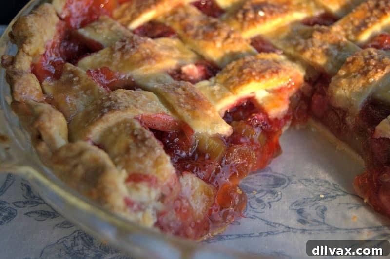A close-up of the lattice crust on a Strawberry Rhubarb Pie, showing the intricate woven pattern and golden-brown perfection.