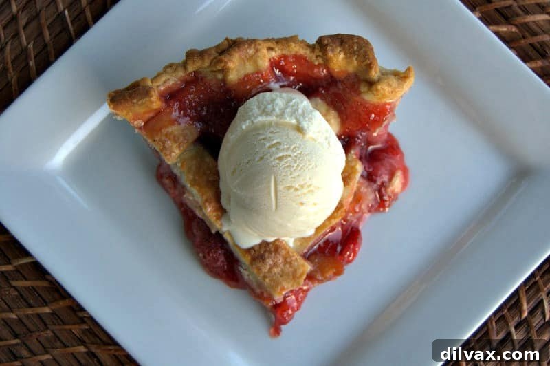 A close-up shot of the raw pie crust strips being woven into a lattice pattern over the strawberry rhubarb filling.