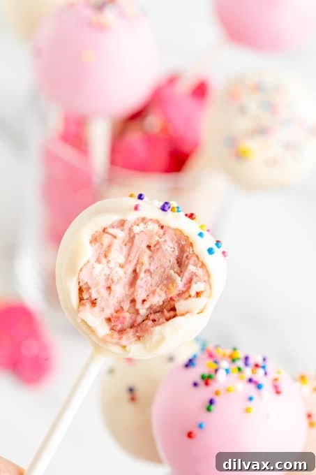 Carnival Cookie Pops 10 A bite taken out of a no bake cookie pop, showing the cookie and cream cheese center.