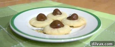 Close-up of a perfectly baked chocolate covered cherry thumbprint cookie