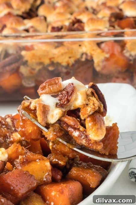 A bite of Molasses Sweet Potato Casserole with marshmallow and pecan.