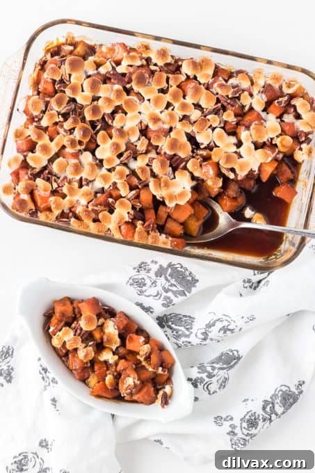 Marshmallows, pecans, and molasses glaze on sweet potato casserole, close-up.