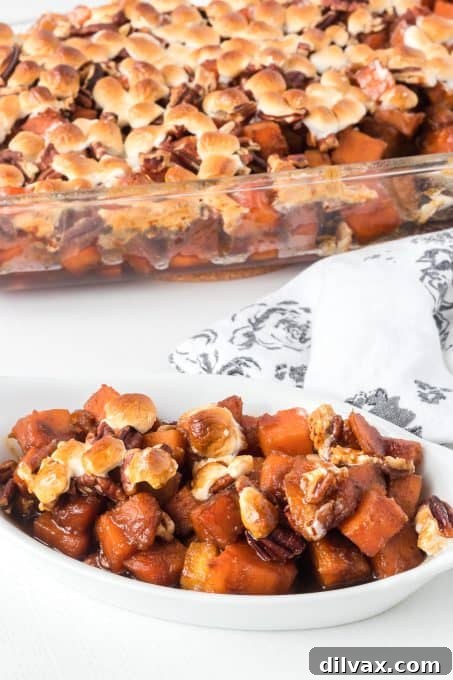 A serving of sweet potato side dish with marshmallows and pecans.
