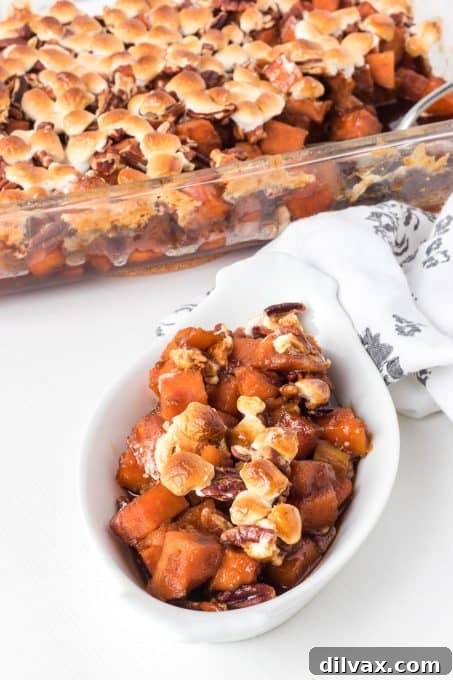 Sweet potatoes with molasses, pecans, and marshmallows in a festive setting.