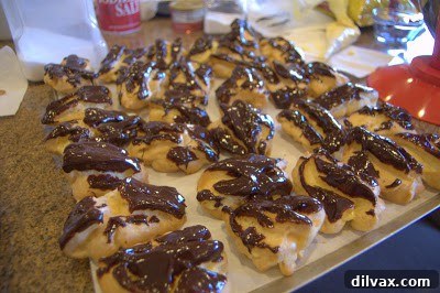 A Two Day Baking Bonanza 24 Eclairs finished with chocolate ganache, gleaming and ready to be served.