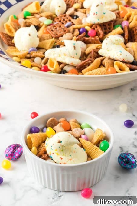 A close-up of colorful Peeps, crunchy pretzels, and various Easter candies beautifully mixed into Chex cereal for a festive snack.
