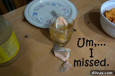 A piece of salmon that has fallen into a glass of apple juice.