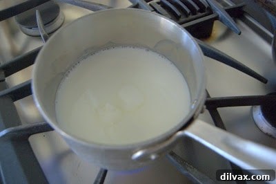 Shortening, sugar, salt, milk, and water melting in a saucepan on low heat.