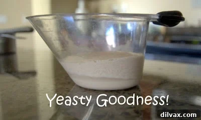 Yeast mixture dissolving in warm water, showing foam.