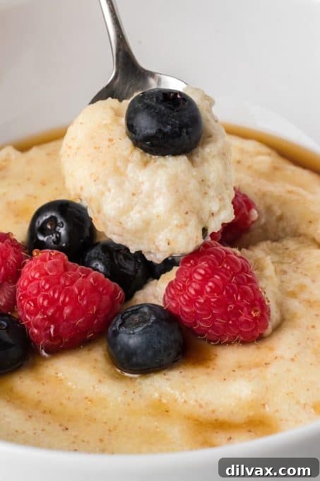 A spoonful of Cream of Wheat® being lifted from a bowl, showcasing its creamy texture.