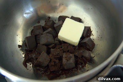 Unsweetened chocolate and butter melting gently in a bowl over a simmering saucepan.
