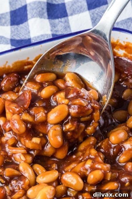 Sweet & Savory Bean Bake 7 Beans made from scratch, glistening with a rich, dark sauce in a ceramic dish.