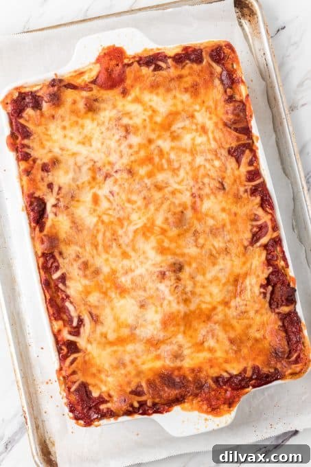 A deep 9x13 inch baking dish filled with assembled cottage cheese lasagna layers, ready for the oven.