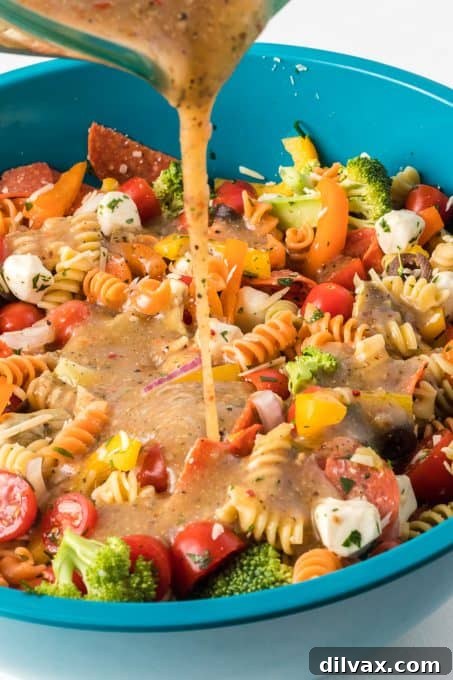Vibrant Italian Pasta Medley 6 Pouring zesty Italian dressing over a vibrant pasta salad, enhancing its flavor profile.
