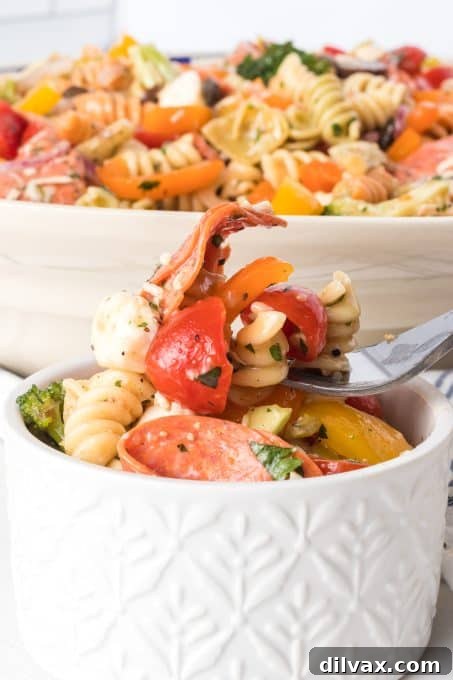 Vibrant Italian Pasta Medley 10 A close-up shot of a single bite of Italian pasta salad on a fork, showing its fresh ingredients and inviting texture.