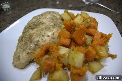 A beautifully plated serving of roast chicken, accompanied by perfectly roasted butternut squash and potatoes, ready to be enjoyed.