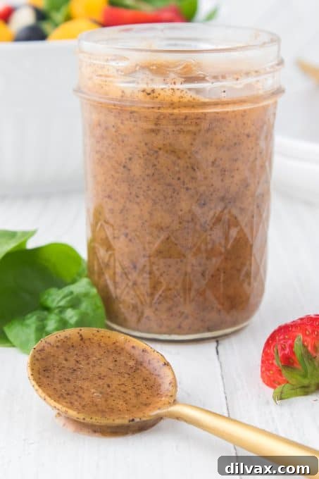 Another perspective of the poppy seed salad dressing in a mason jar, highlighting its inviting appearance.
