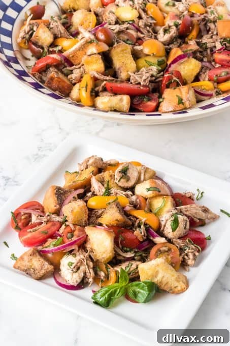 Rustic Chicken Panzanella 5 Toasted bread, colorful tomatoes, red onion, fresh basil, and mozzarella harmoniously combined with olive oil and balsamic vinegar in a bowl.