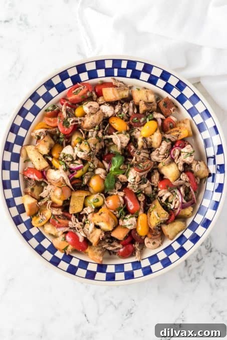 Rustic Chicken Panzanella 9 A large bowl of bread salad brimming with colorful tomatoes, fresh mozzarella, and herbs.