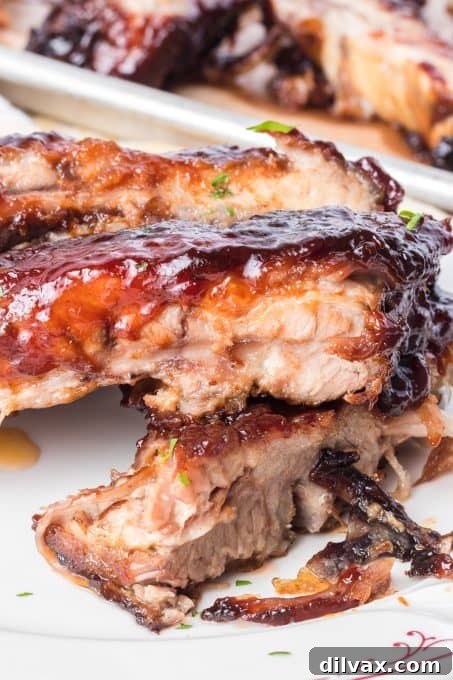 A beautifully presented serving of Pork Spare Ribs on a white plate with a side dish.