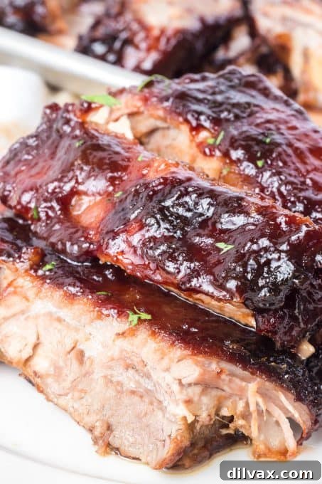 Close-up detail of glazed pork spare ribs in an oven, showcasing the caramelized sauce.