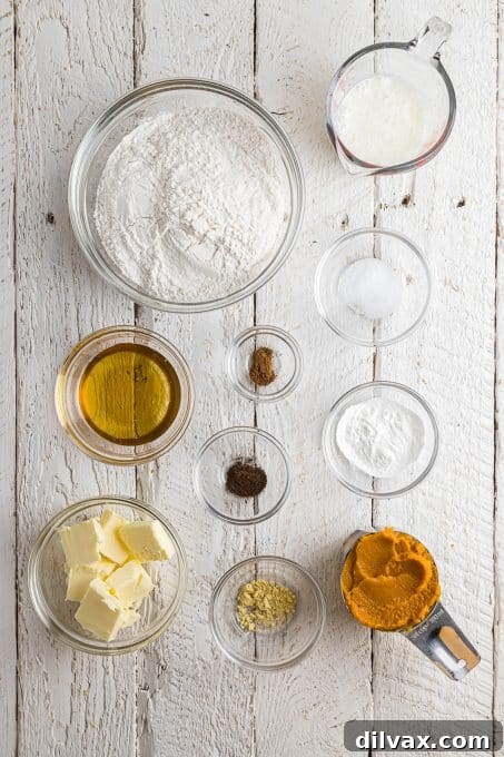 Golden Pumpkin Delights 4 Various ingredients for pumpkin biscuits laid out on a wooden surface.