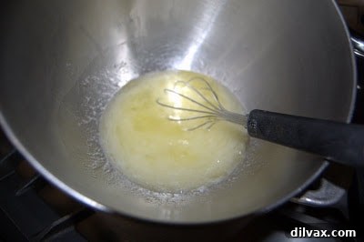 Ingredients for meringues in a mixing bowl over simmering water.
