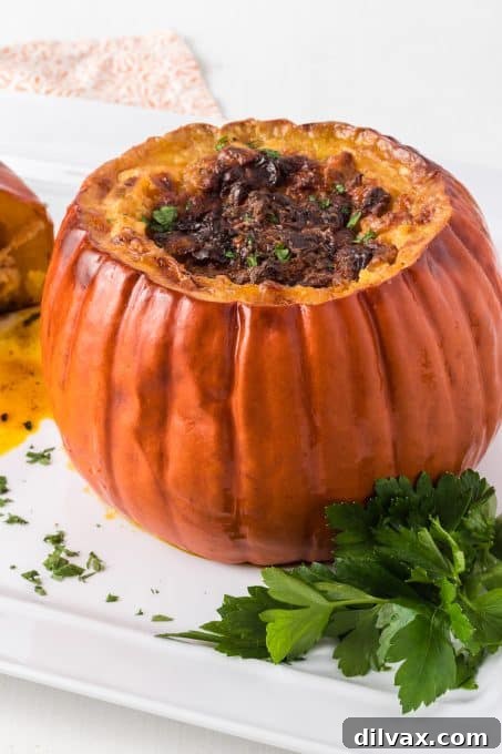 A whole stuffed pumpkin, ready to be sliced and served, showcasing a rich, cheesy filling.