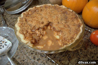 A slice of soupy apple crumb pie on a plate