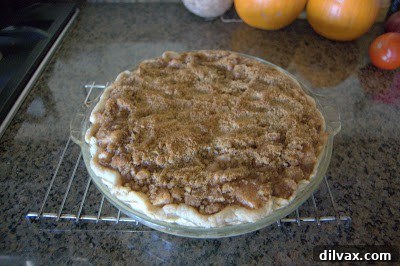 Freshly baked apple crumb pie cooling on a wire rack