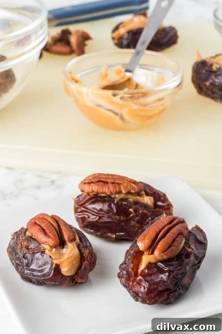 An easy and healthy snack of dates, peanut butter and pecans on a marble surface.