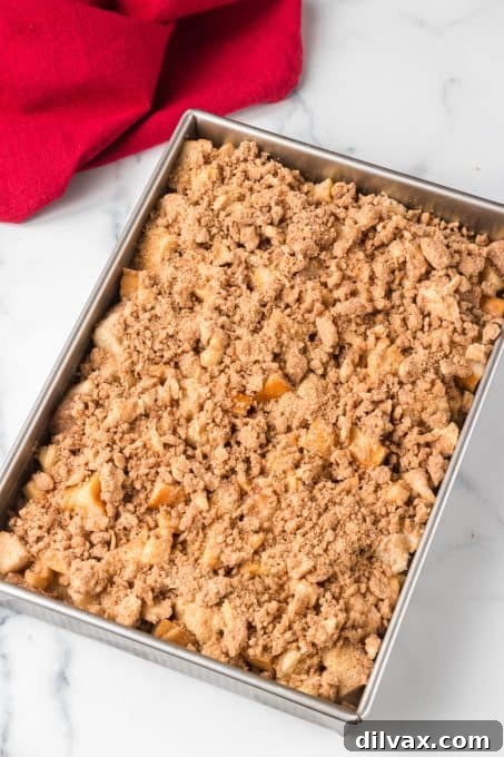Sticky Caramel Apple French Toast Bake 6 Cinnamon streusel topping being generously applied to the French toast bake before going into the oven.