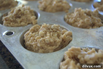 Day 241 - Delicious Peanut Butter Banana Muffins 4 Muffin tin filled with batter and topped with walnuts, ready for baking
