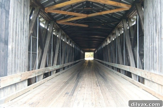 Exterior view of Mt. Orne Covered Bridge #30 with fall foliage and river in background, Lancaster, NH