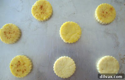 Cheese Cornmeal Biscuits 6 Biscuits arranged on baking sheet, brushed with egg yolk and sprinkled with paprika